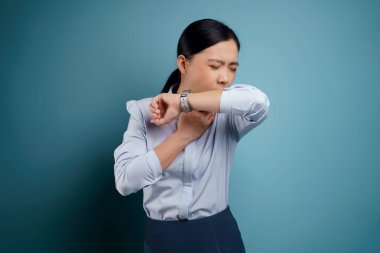 Asyalı kadın hastaydı, ateşi vardı ve mavi arka plandaydı..