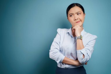 Kopyalama alanıyla kafası karışmış Asyalı kadın. Arkaplanda izole.