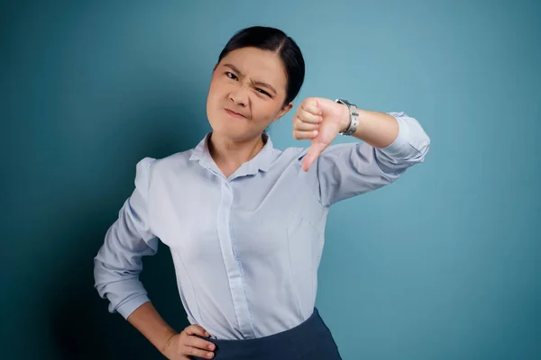 Azji Kobieta Irytowany Pokazując Kciuk Dół Odizolowany Niebieskim Tle — Zdjęcie stockowe