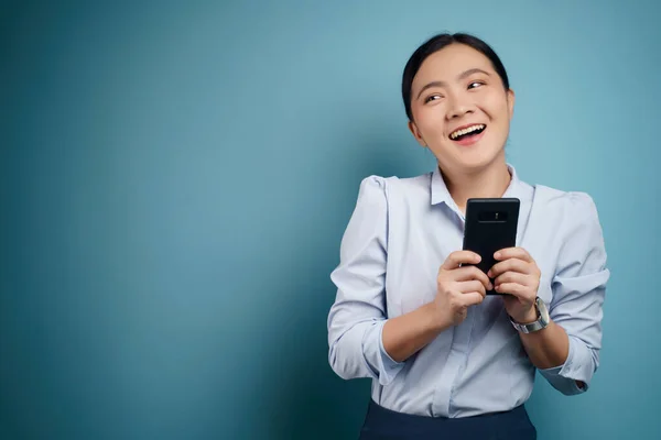 アジアの女性の幸せな入力メッセージスマートフォンを背景に隔離された — ストック写真