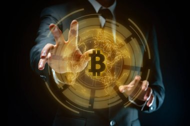 Bitcoin sembollü hologram efektli siyah takım elbiseli bir iş adamının yakın plan çekimi..