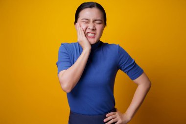 Asyalı kadın hastaydı. Dişi ağrıyordu. Yanağına dokunuyordu..