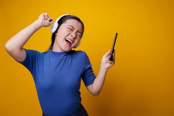 Asijské Žena Sluchátky Poslech Hudby Chytrého Telefonu Izolované Žlutém Pozadí — Stock fotografie