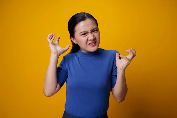 黄色の背景に隔離された立って怒っているアジアの女性 — ストック写真