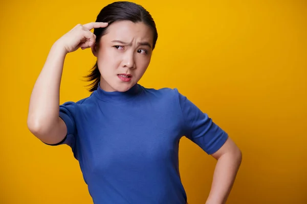 Förvirrad Asiatisk Kvinna Tänker Och Står Isolerad Gul Bakgrund — Stockfoto
