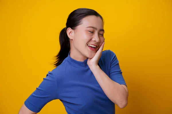 幸せなアジアの女性ショーおもちゃの笑顔立って孤立した上に黄色の背景 — ストック写真