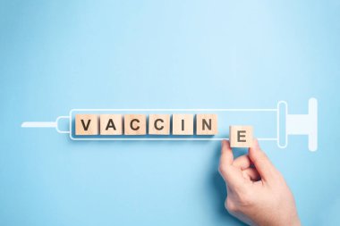 Şırınga simgesi mavi arkaplan üzerinde izole edilmiş ahşap blok üzerinde 