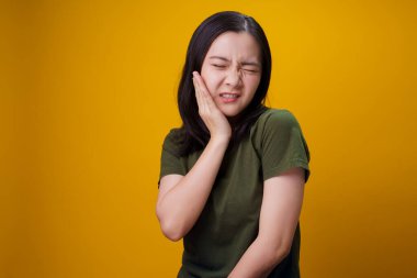 Asyalı kadın hastaydı. Dişi ağrıyordu. Yanağına dokunuyordu..