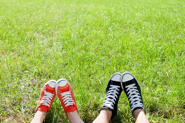 Πόδια σε πάνινα παπούτσια για την πράσινη χλόη — Φωτογραφία Αρχείου