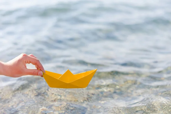 Female hand holding paper boat — Stock Photo, Image