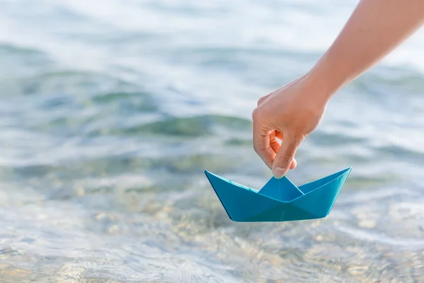 Feminino mão segurando barco de papel — Fotografia de Stock