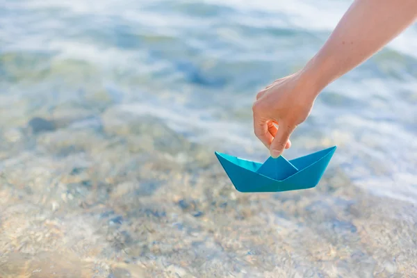 Feminino mão segurando barco de papel — Fotografia de Stock