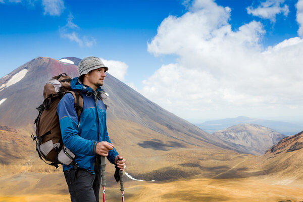 Молодой человек в солнечный день прогулки в высоких горах
