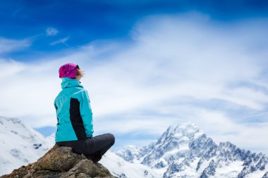 Cliff üzerinde oturan genç kadın