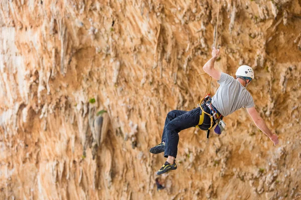 Jeune homme grimpant sur un mur — Photo