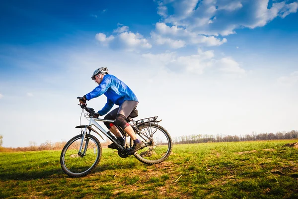 Jovem ciclista montando uma bicicleta — Fotografia de Stock