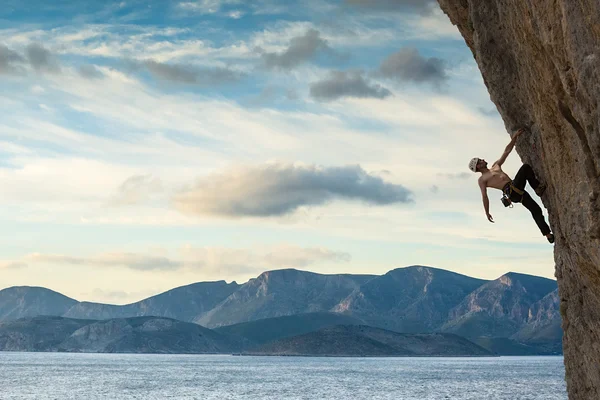 Jeune homme grimpant sur un mur — Photo