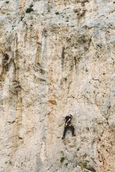 Jeune homme grimpant sur un mur — Photo