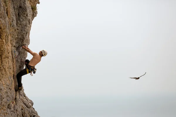 Jeune homme grimpant sur un mur — Photo