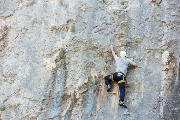 Jeune homme grimpant sur un mur — Photo