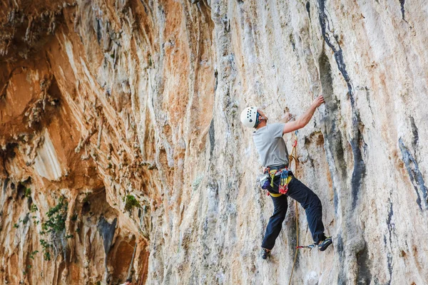 Jeune homme grimpant sur un mur — Photo