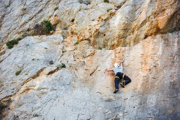 Jeune homme grimpant sur un mur — Photo
