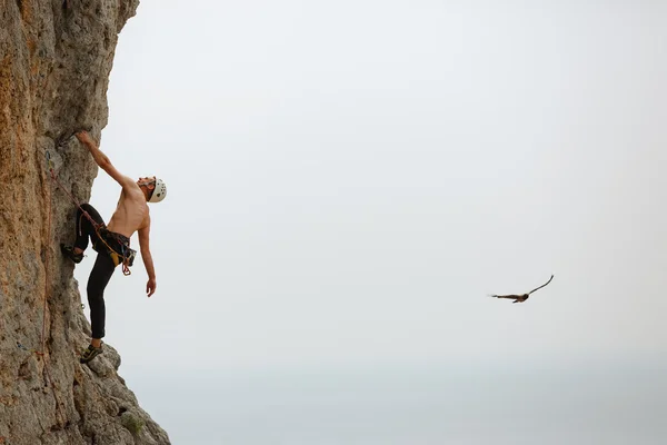 Jeune homme grimpant sur un mur — Photo