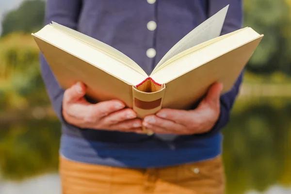 Mani femminili che tengono aperto il libro — Foto Stock