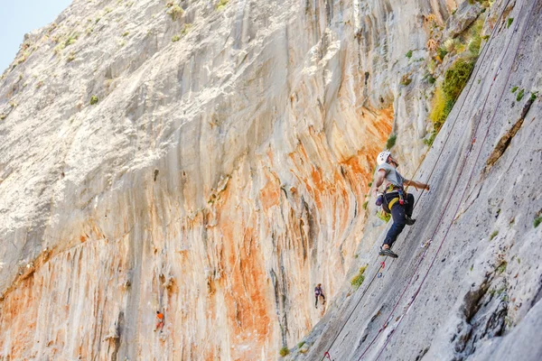 Jovem escalando em uma parede — Fotografia de Stock