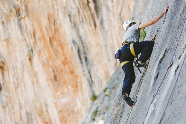 Jeune homme grimpant sur un mur — Photo