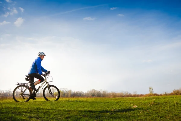 Jovem ciclista montando uma bicicleta — Fotografia de Stock