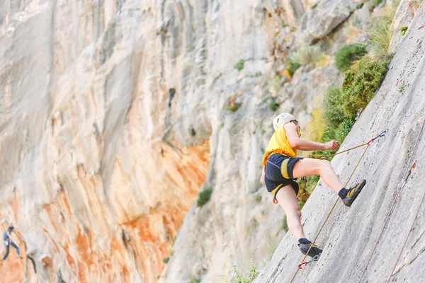 Jeune homme grimpant sur un mur — Photo