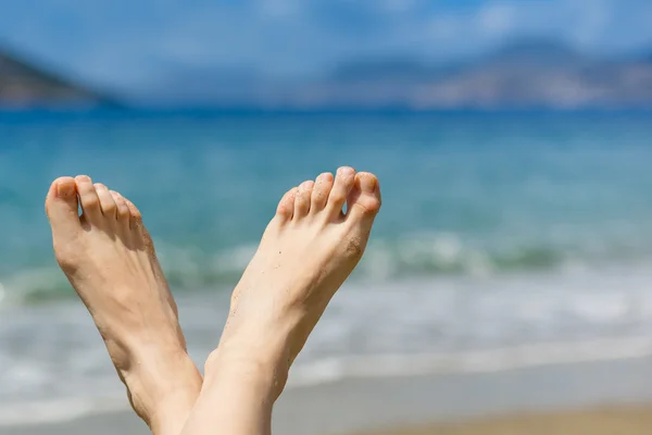 Kadın ayakları üzerinde beach — Stok fotoğraf