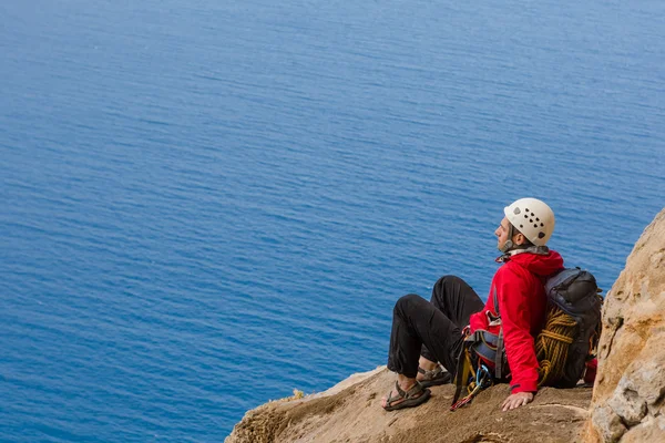 Grimpeur ayant du repos assis sur le rocher — Photo