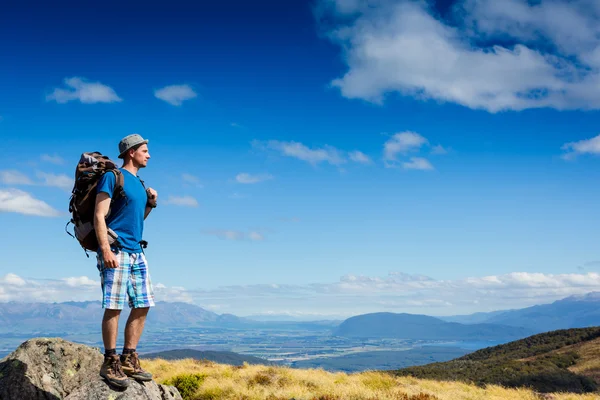 Turista com mochila e panorama de montanha — Fotografia de Stock