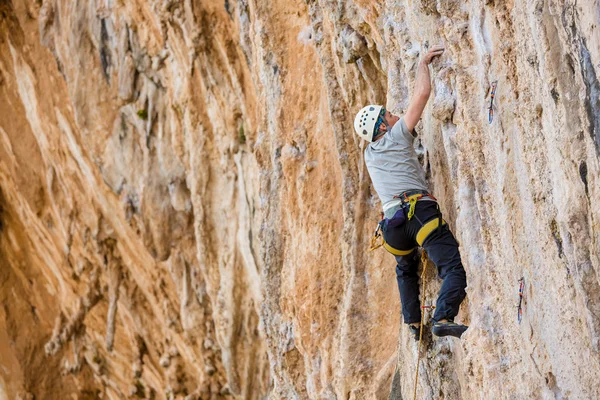 Jovem escalando em uma parede — Fotografia de Stock