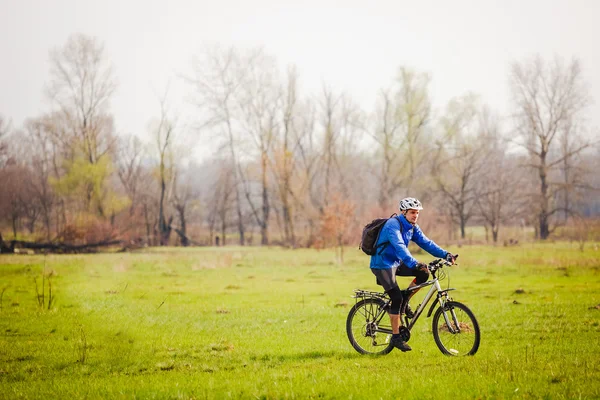 Jovem ciclista montando uma bicicleta — Fotografia de Stock