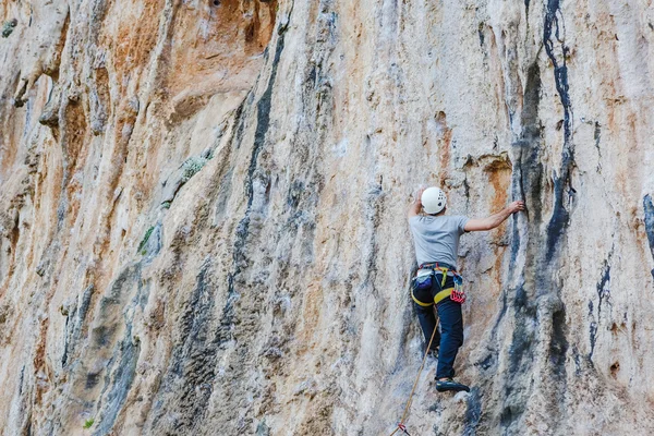 Jeune homme grimpant sur un mur — Photo