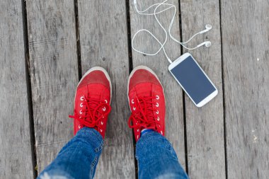 kırmızı spor ayakkabılar ve akıllı telefon 