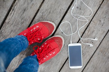 kırmızı spor ayakkabılar ve akıllı telefon 