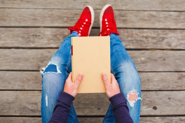 Menina em um cais com um livro — Fotografia de Stock