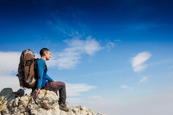 Turysta siedzi na klifie — Zdjęcie stockowe
