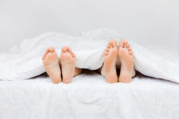 Fyra fötter i en säng — Stockfoto