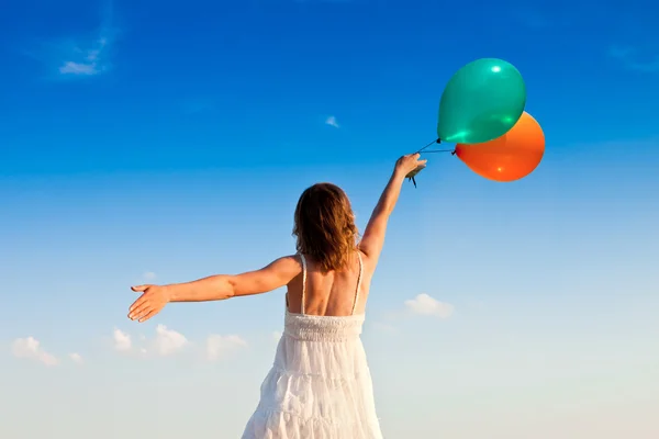 Mädchen mit bunten Luftballons im Sonnenuntergang — Stockfoto