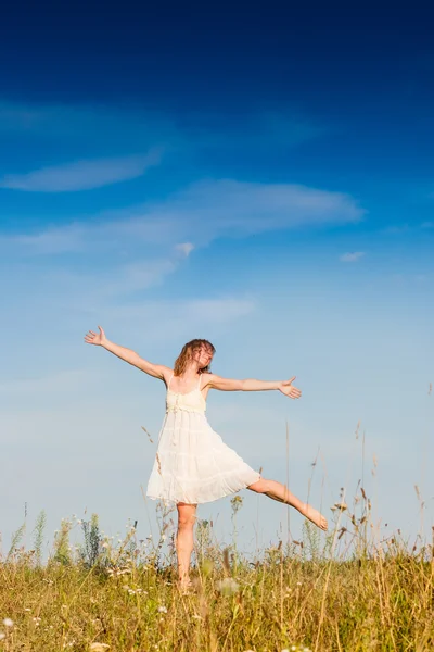 Young woman jumping in the meadow Stock Photo