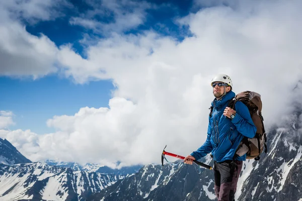 Alpiniste avec piolet atteint le sommet — Photo