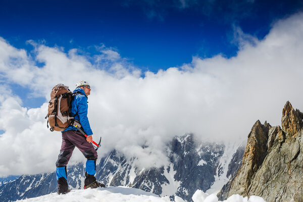 Mountaineer reaches the top of a mountain