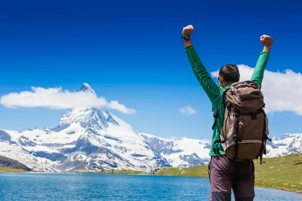 Man traveler with hands raised in mountains — Stock Photo, Image