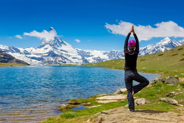 Mujer está practicando yoga en las montañas — Foto de Stock