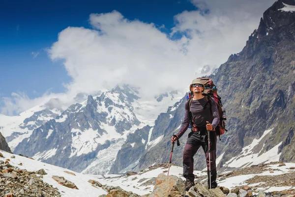 Caminhante com mochila em pé nas montanhas — Fotografia de Stock